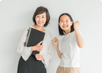 成績アップをし喜んでいる生徒と講師のイメージ写真